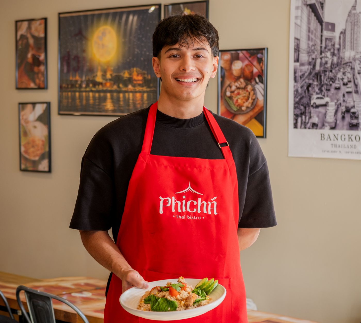 Phicha team member holding a plate of fried rice
